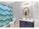 Well-lit bathroom with a gold-framed mirror, single sink vanity, and shower with a patterned curtain at 898 Allene Sw Ave, Atlanta, GA 30310