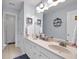 Bathroom featuring double sinks, vanity, mirror, and tiled floors at 905 Fox Croft Pl, Canton, GA 30114