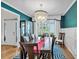 Elegant dining room featuring modern chandelier, blue accent wall, and a large window at 905 Fox Croft Pl, Canton, GA 30114