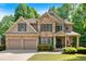 Beautiful stone-and-siding two-story home with manicured lawn, two-car garage, and mature trees at 905 Fox Croft Pl, Canton, GA 30114