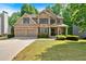 Charming two-story home with a stone facade, well-manicured lawn, and a welcoming two-car garage at 905 Fox Croft Pl, Canton, GA 30114