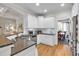 Spacious kitchen featuring granite countertops, stainless steel appliances, white cabinets and an open layout to the breakfast nook at 905 Fox Croft Pl, Canton, GA 30114
