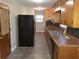 Functional kitchen with black appliances, wood cabinets, and tile floors at 1170 Blair Bridge Rd, Austell, GA 30168