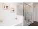 Elegant bathroom featuring a luxurious soaking tub and a modern glass-enclosed shower, with stylish tile work and fixtures at 1771 Jordan Brook Dr, Lawrenceville, GA 30043