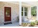 Inviting front porch with seating area and a stylish red front door at 1771 Jordan Brook Dr, Lawrenceville, GA 30043