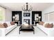 Bright living room with white sofas, a fireplace, and a black chandelier at 1771 Jordan Brook Dr, Lawrenceville, GA 30043