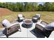 Outdoor patio featuring wicker chairs around a fire pit and a serene backyard setting at 1771 Jordan Brook Dr, Lawrenceville, GA 30043