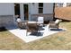 Patio with wicker chairs, fire pit and white brick exterior provides a modern and comfortable outdoor living space at 1771 Jordan Brook Dr, Lawrenceville, GA 30043