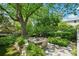 Beautiful stone patio with wood dining furniture set amongst professionally landscaped backyard at 20 S Prado Ne, Atlanta, GA 30309