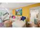 Bright living room with yellow accent wall, comfortable seating, and staircase in background at 20 S Prado Ne, Atlanta, GA 30309