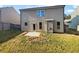 View of the home's back exterior featuring a grassy backyard and a concrete patio at 4428 Belcamp Rd, Fairburn, GA 30213