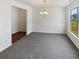 Open dining room featuring neutral paint, soft carpet, wainscotting and a chandelier at 4428 Belcamp Rd, Fairburn, GA 30213