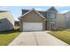 Inviting two-story home featuring a two-car garage and well-maintained lawn with blue shutters on the windows at 4428 Belcamp Rd, Fairburn, GA 30213