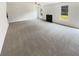 Spacious living room featuring plush carpet, a cozy fireplace, and lots of natural light from large windows at 4428 Belcamp Rd, Fairburn, GA 30213