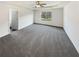 Spacious main bedroom featuring a tray ceiling, soft carpet, and a large window overlooking the backyard at 4428 Belcamp Rd, Fairburn, GA 30213