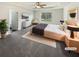 Bright main bedroom featuring a tray ceiling, soft carpet, and a large window with a view to the back yard at 4428 Belcamp Rd, Fairburn, GA 30213