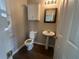 This bathroom features a pedestal sink and toilet with wood-look flooring at 3835 Portico Run Dr, Buford, GA 30519
