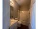 This bathroom features a tub/shower combo and a single sink vanity with wood-look floors at 3835 Portico Run Dr, Buford, GA 30519
