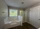Bathroom features a soaking tub with tile surround, glass enclosed shower, and wood-look flooring at 3835 Portico Run Dr, Buford, GA 30519