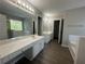 Primary bathroom offering double sink vanities, soaking tub, walk-in shower and wood-look floors at 3835 Portico Run Dr, Buford, GA 30519