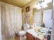 Bathroom with a shower/tub combo, floral curtain, light wood vanity, and a large mirror at 5607 Stonington Trace Pkwy, Stone Mountain, GA 30087
