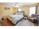Bedroom featuring hardwood floors, a plush recliner, and a large bed with decorative pillows at 5607 Stonington Trace Pkwy, Stone Mountain, GA 30087