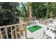 Outdoor deck area features a table with umbrella and chair set against a backdrop of trees at 5607 Stonington Trace Pkwy, Stone Mountain, GA 30087