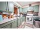 Well-lit kitchen features sage-painted cabinets, granite countertops, and modern appliances at 5607 Stonington Trace Pkwy, Stone Mountain, GA 30087