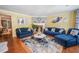 Cozy living room featuring hardwood floors, fireplace, and comfortable blue sofas at 5607 Stonington Trace Pkwy, Stone Mountain, GA 30087