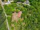 Drone shot shows a home with lush surrounding trees, complemented by a red roof and a peaceful, secluded environment at 751 Upper Burris Rd, Canton, GA 30114