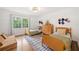 Bright bedroom with twin beds, a dresser, and a large window offering a serene view of the outdoors at 751 Upper Burris Rd, Canton, GA 30114