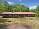 Beautiful single story brick home featuring a metal roof, black shutters, green yard and a wooden fence in a wooded setting at 751 Upper Burris Rd, Canton, GA 30114