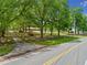 Charming home with a brick façade, wooden fence and red roof, surrounded by lush greenery and mature trees at 751 Upper Burris Rd, Canton, GA 30114
