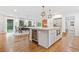 Bright, open kitchen with an island, wine cooler, and dining area featuring large windows overlooking the yard at 751 Upper Burris Rd, Canton, GA 30114