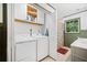 Functional laundry room with washer, dryer, overhead storage and neutral decor at 751 Upper Burris Rd, Canton, GA 30114