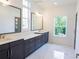 Modern bathroom featuring double sinks, mirrors, large window and marble tile flooring at 1432 Fairmont Ave, Atlanta, GA 30318