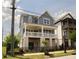 Charming two-story home with a covered front porch and manicured lawn and dark metal fencing at 1432 Fairmont Ave, Atlanta, GA 30318
