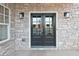 Elegant double front door framed by stone, complemented by stylish sconces and a window at 1432 Fairmont Ave, Atlanta, GA 30318