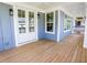 The covered porch features beautiful wood floors, beadboard ceiling, and double glass doors at 1432 Fairmont Ave, Atlanta, GA 30318