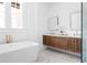 Elegant bathroom with a freestanding tub, dual vanities, marble flooring, and a view from the window at 1585 S Ponce De Leon Ne Ave # 19, Atlanta, GA 30307