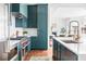 Modern kitchen featuring teal cabinets, stainless steel appliances, white countertops, and an open design into the living space at 1585 S Ponce De Leon Ne Ave # 19, Atlanta, GA 30307