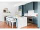 Stylish kitchen with a large island, white countertops, teal cabinetry, stainless steel appliances, and hardwood flooring at 1585 S Ponce De Leon Ne Ave # 19, Atlanta, GA 30307