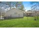 Exterior view of the home with lush green grass, a fenced yard, and mature trees at 200 Harvell Dr, Bowdon, GA 30108