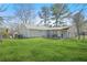 View of the backyard, showcasing a well-kept lawn, back porch, and fenced perimeter at 200 Harvell Dr, Bowdon, GA 30108