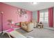 Bedroom with pink accent wall, crib, chair, and natural light from the large window at 200 Harvell Dr, Bowdon, GA 30108