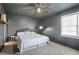 A bedroom featuring dark walls and a white ceiling fan, with a bed and a window at 200 Harvell Dr, Bowdon, GA 30108
