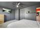 A bedroom featuring dark walls with a TV, and a white ceiling fan, with a bed and closets at 200 Harvell Dr, Bowdon, GA 30108