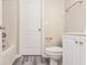 Well-lit bathroom boasts gray vinyl floors and a shower-tub combo at 407 Red Coat Ln, Woodstock, GA 30188
