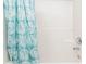 Close-up on white tiled shower and patterned blue shower curtain at 407 Red Coat Ln, Woodstock, GA 30188