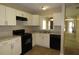 Well-lit kitchen with white cabinets and black appliances at 490 Culberson Sw St, Atlanta, GA 30310